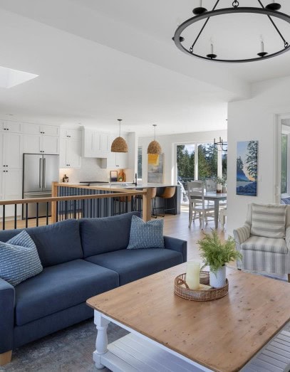 Benjamin Moore White Dove in open concept living room, dining room, kitchen blue sofa and accent colors. Lake home palette and style, area rug, coffee table, home decor
