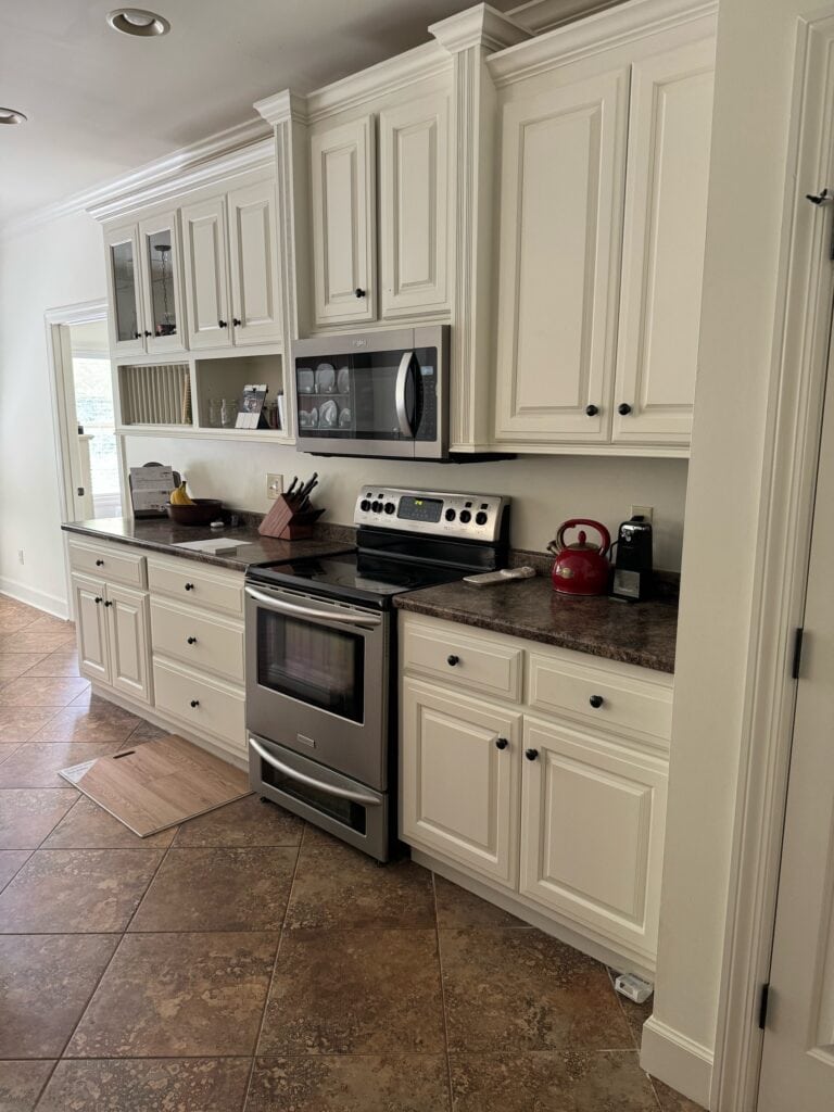 Kitchen with Sherwin Williams Dover White cabetsin and walls, brown granite look laminate formica countertop, orange and brown beige tile floor