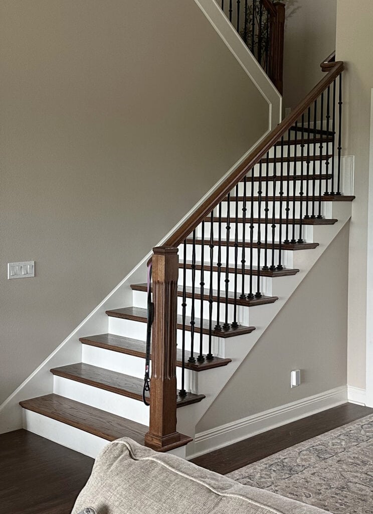 Open concept entryway, stairs, Sherwin Williams Accessible Beige, Alabaster trim and doors, wood stairs, white risers, dark wood floor (1)