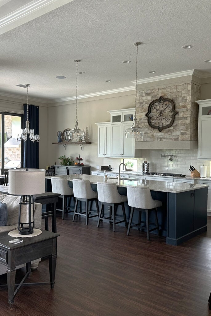 Sherwin Williams Accessible Beige on walls, Alabaster trim and cabinets, large island, dark wood floor, navy blue accents (1)