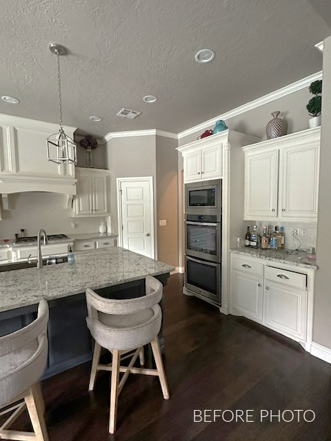 Sherwin Williams Creamy cabinets and trims with beige walls, dark wood floor, granite countertop and cream subway tile