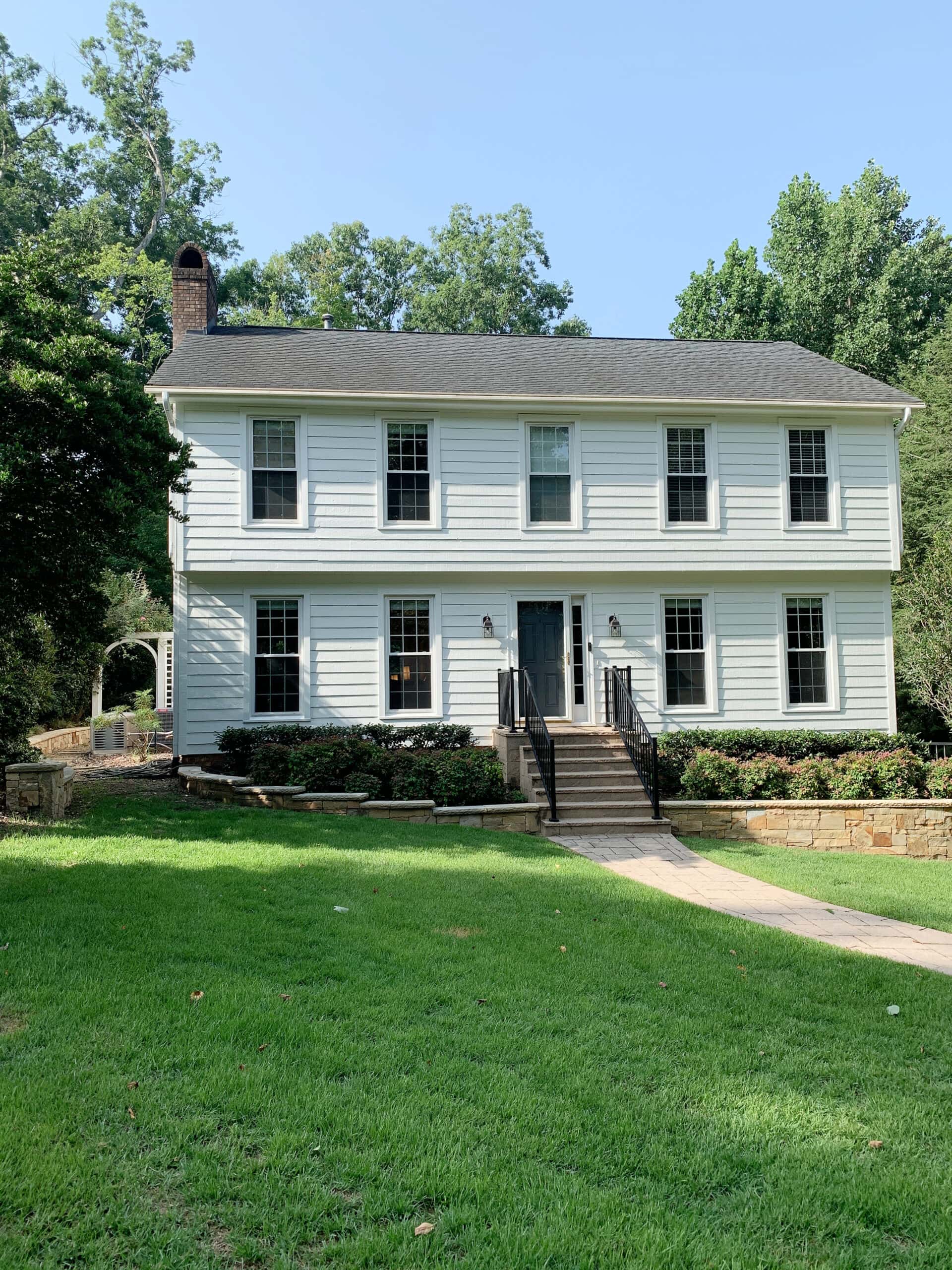 Sherwin Williams Pure White painted exterior vinyl siding, taupe fibreglass roof, white windows, Benjamin Moore Gray 2121-10 on painted front dor