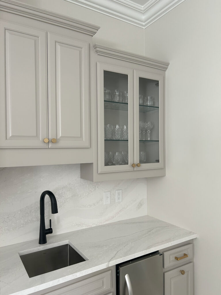 Bar sink with black faucet, Benjamin Moore Taupe paint color on painted kitchen cabinets, countersplash and countertop quartz Cambria Everleigh