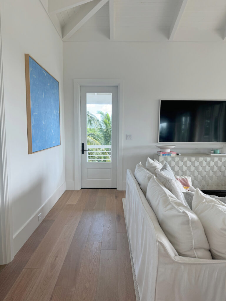 Beach house with vaulted ceiling in shiplap with beams, walls and trims Sherwin Williams Snowbound, wood oak floor. Beach home of LeMel Jewelry owner
