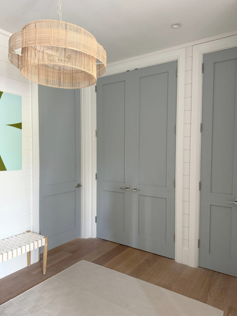 Bedroom and closet doors painted blue-gray paint color, Benjamin Moore Boothbay Gray, oak wood floor, walls and trims, Sherwin Williams Snowbound warm white, beach h