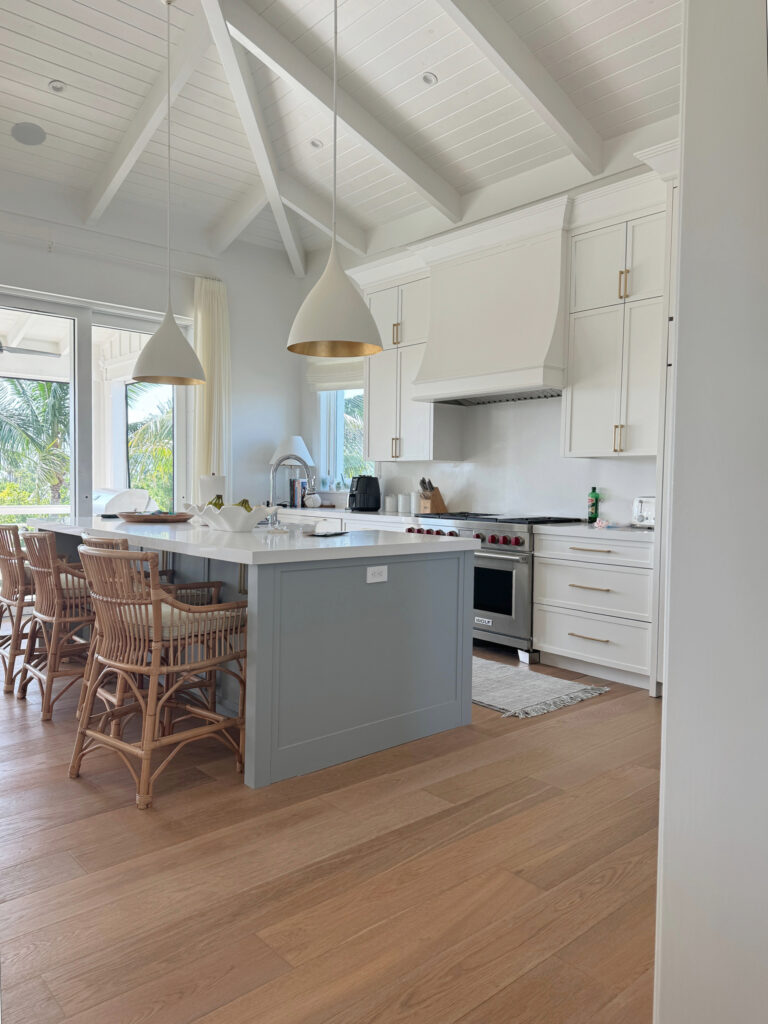 Island painted Benjamin Moore Boothbay Gray, cabinets are Sherwin Williams Snowbound, vaulted ceiling with white painted shiplap and beams, white quartz