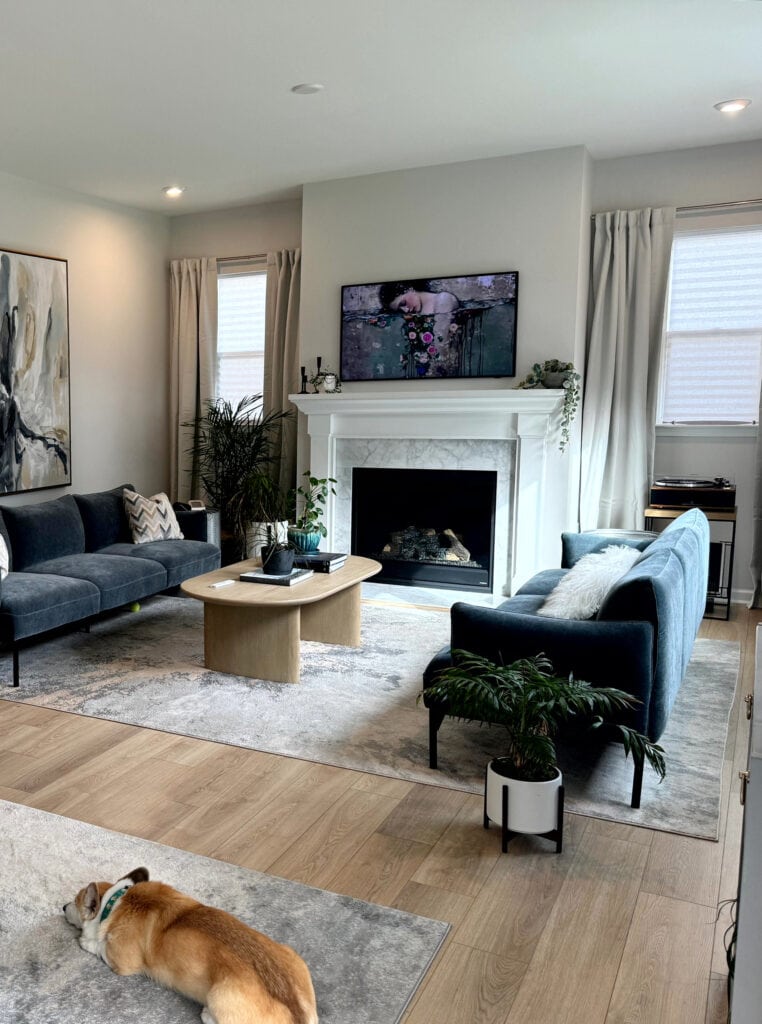 Living room, extra white trim, mantle, marble fireplace surround, blue-green sofas, Sherwin Williams First Star gray blue walls, wood floor, round dining table (1)