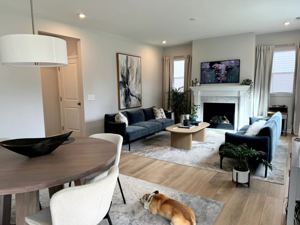Living room, extra white trim, mantle, marble fireplace surround, blue-green sofas, Sherwin Williams First Star gray blue walls, wood floor, round dining table
