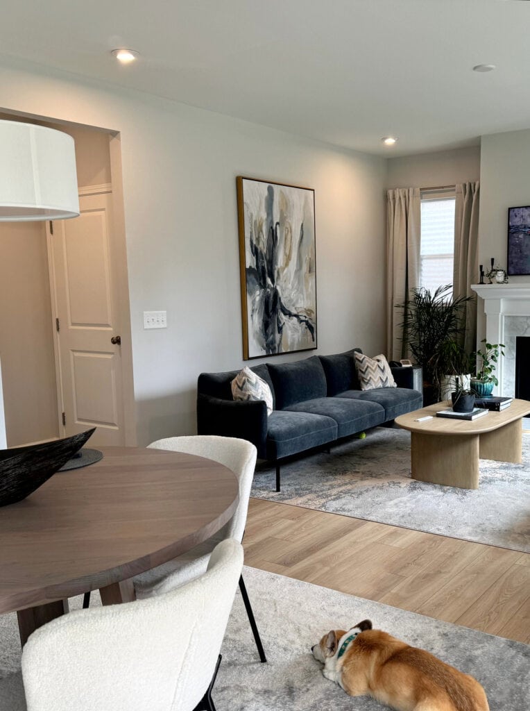 Living room, extra white trim, mantle, marble fireplace surround, blue-green sofas, Sherwin Williams First Star gray blue walls, wood floor, round dining table (2)