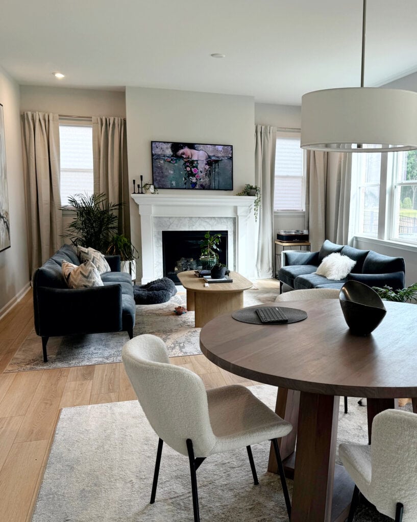 Sherwin Williams First Star, gray blue open concept small spae, round dining table, wood floor, blue-green sofas, marble fireplace surround, Extra White