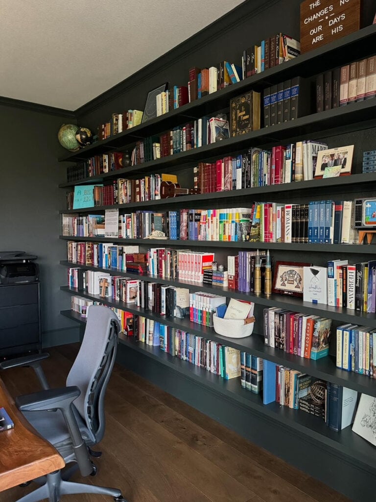 Sherwin Williams Rock Bottom, dark green with blue gray paint color, wall to wall floating book shelves, dark wood floor, home office