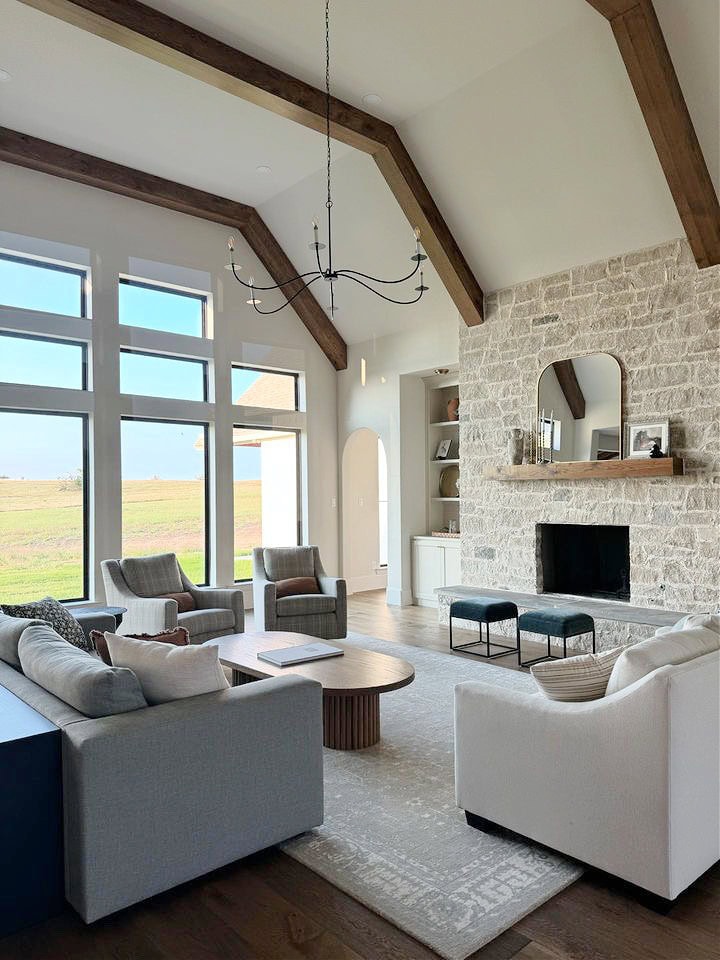 Sherwin Williams off-white paint color, stone fireplace with cream and beige, wood floor, accent chairs, builtin