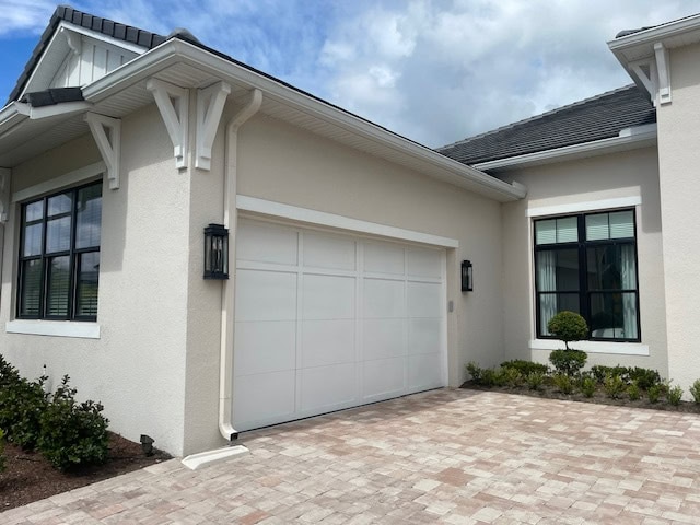 light tan paint color with white trim, black windows, orange, pink, gray stone drivway, white garage door, exterior colors