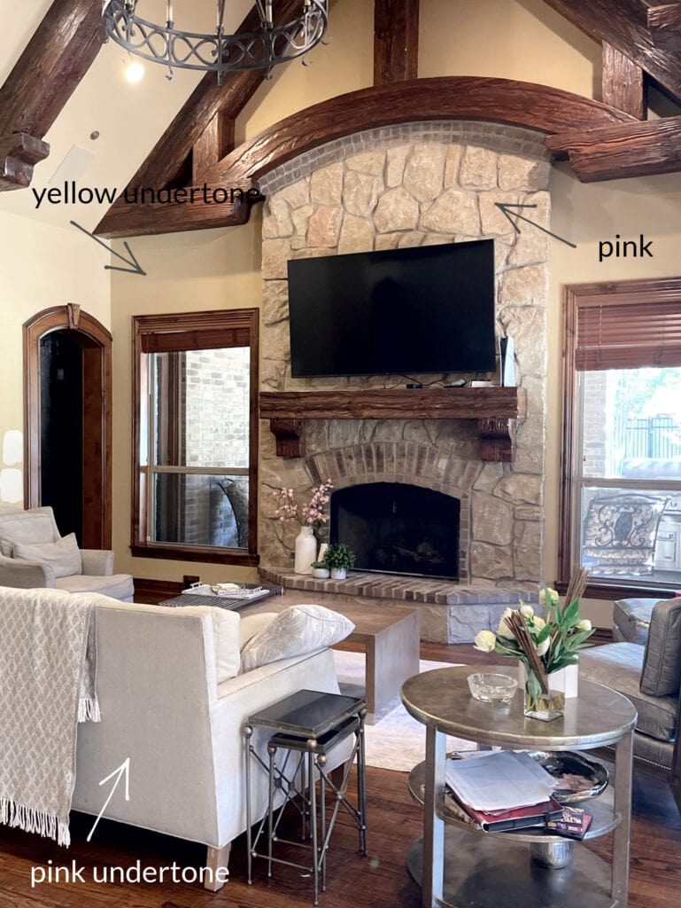living room with stone fireplace arched wood ceiling and wall beams, rustic mantel, dark wood floor, home decor, wood trim adn furniture, beige walls (1)