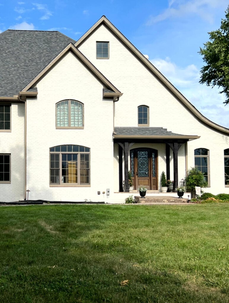 Benjamin Moore Seapearl on the exterior stucco, off-white with greige taupe trim color, wood front door and beams
