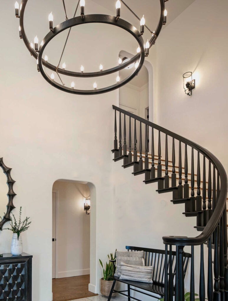 Benjamin Moore White Dove, warm white paint color on two storey vaulted entryway, staircase, black painted wood hand railing, black light fixtures
