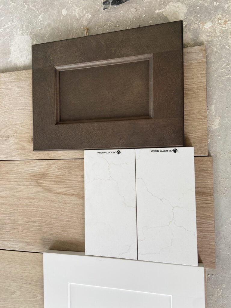 Calacatta Adonia white quartz with warm veining with LVP floor and dark wood island cabinet and white cabinet