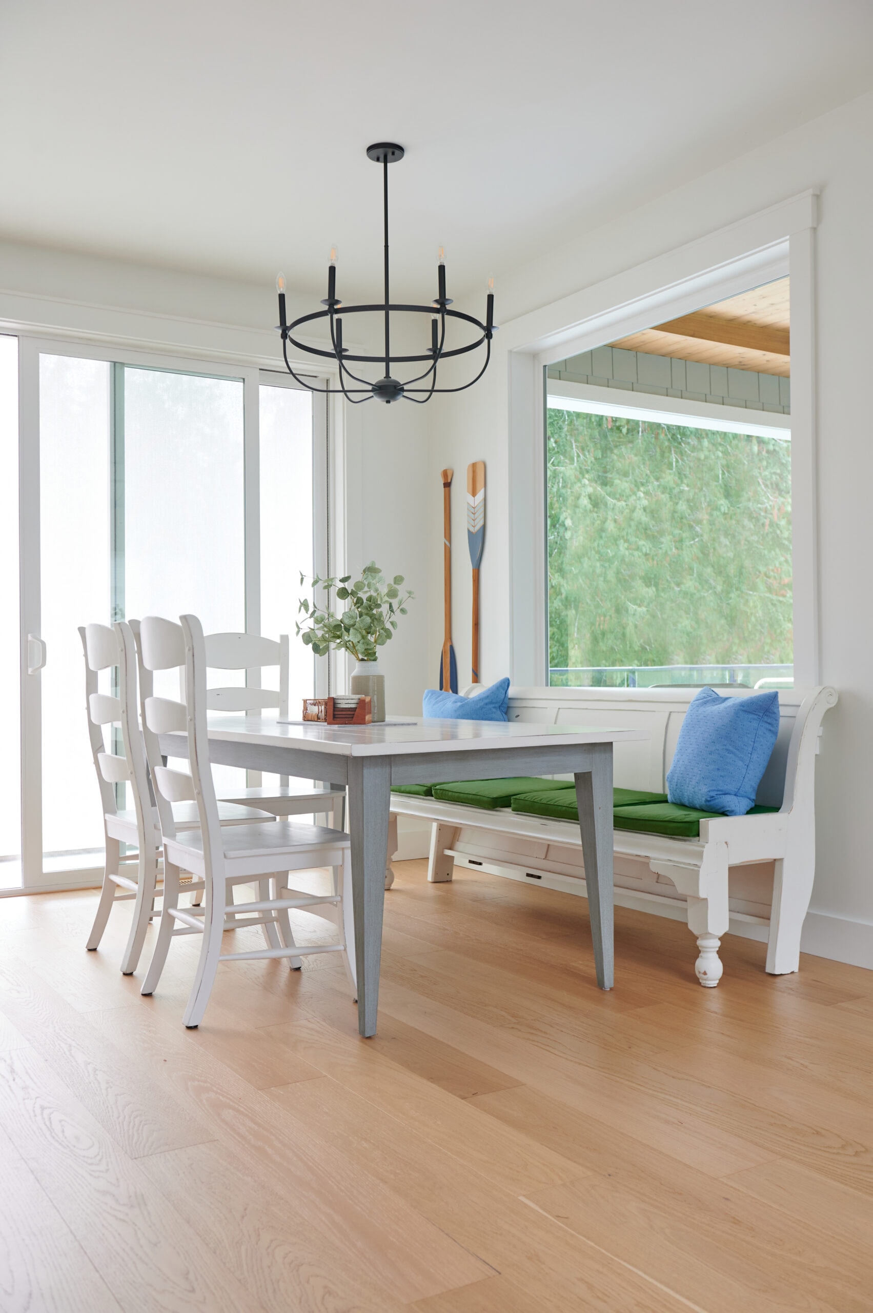 Dining room with church pew for bench, white chairs and table, white oak flooring, BEnjamin Moore White Dove paint color on walls, ceilings