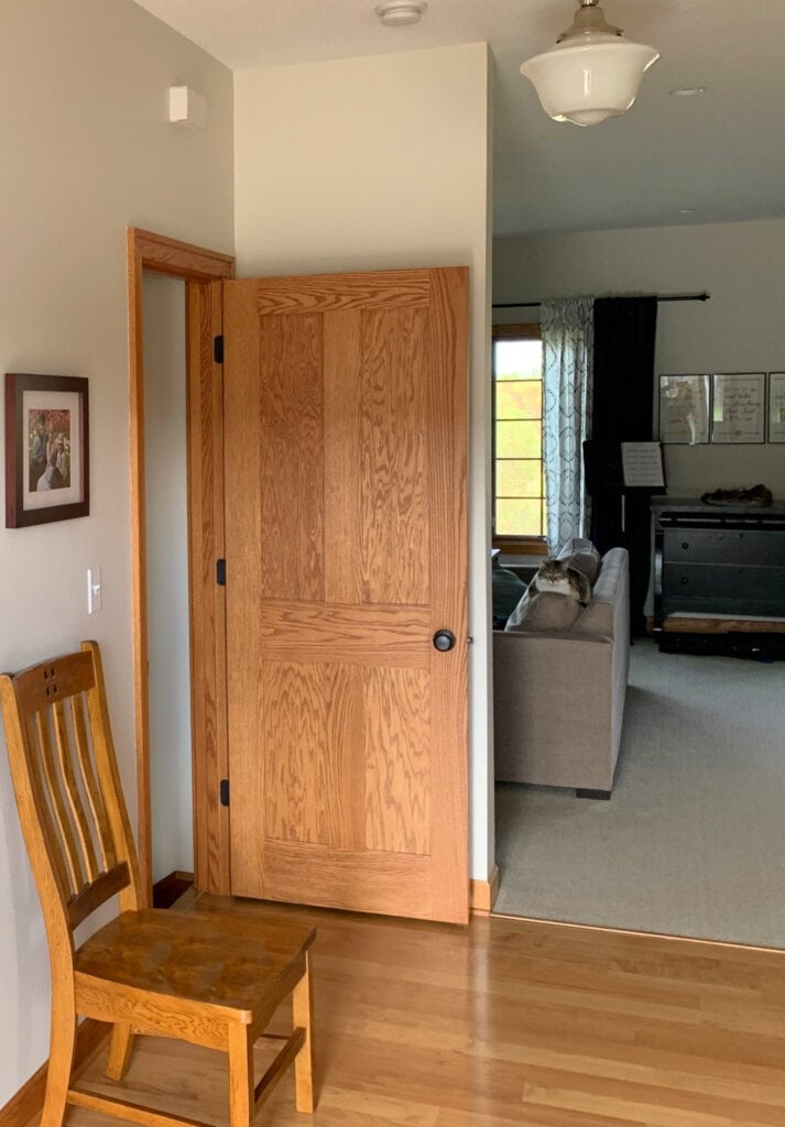 Golden or orange stained red oak doors, trims, and flooring, Sherwin Williams Neutral Ground paint color on walls