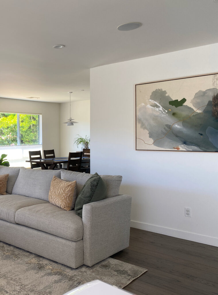 Kelly Moore Swiss Coffee warm white paint color with dark wood floor, neutral sofa, earth-toned west coast color home decor