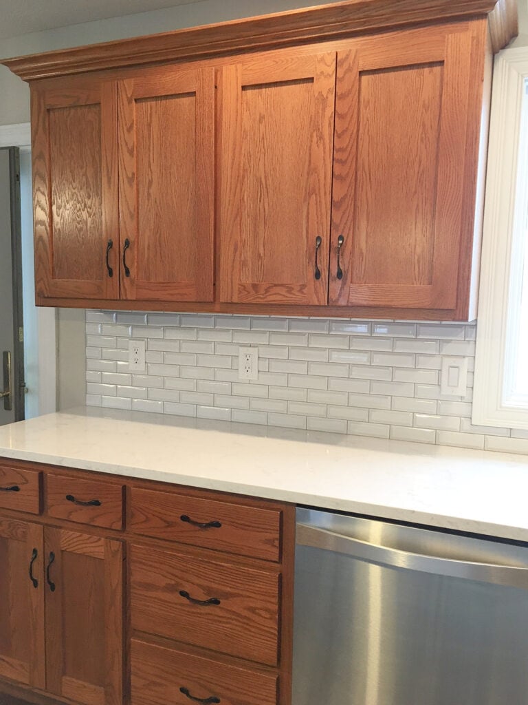 Kitchen cabinets, red oak with white quartz countertop, white subway tile backsplash, home update ideas