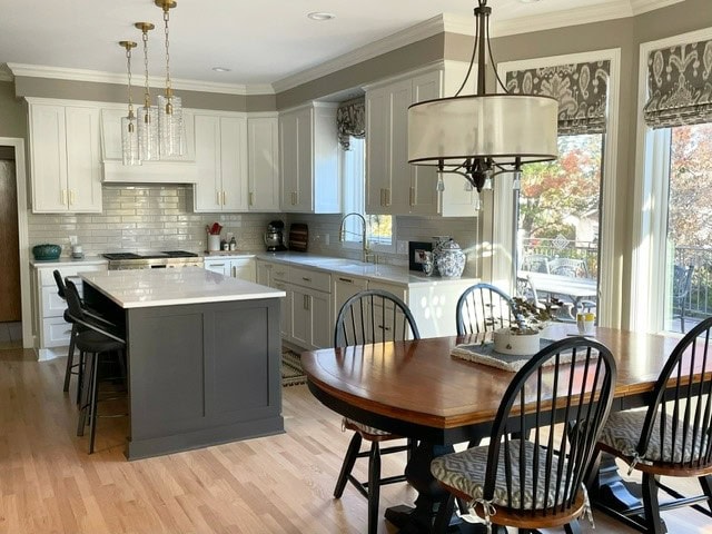 Kitchen walls Benjamin Moore Pashmina, cabinetes Sherwin Williams Cotton, Island Urbane Bronze, red oak floor, white quartz, greige taupe subway tile, gold hardware, eating nook
