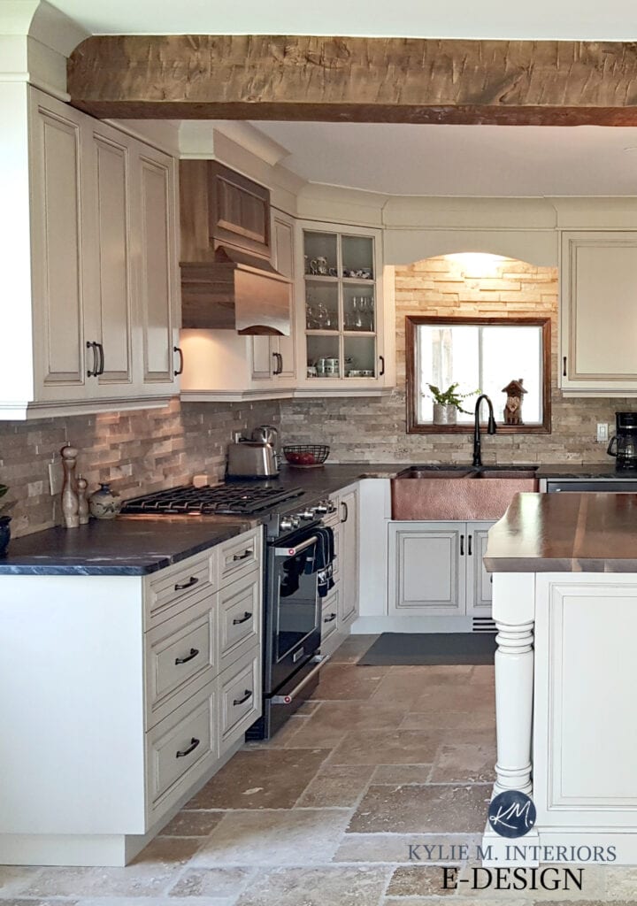 Kitchen with travertine tile floor, Ballet White with glazed painteed cream cabinets, butcher block live edge countertop, travertine backsplash, wood beam, Cedar Key paint colour.