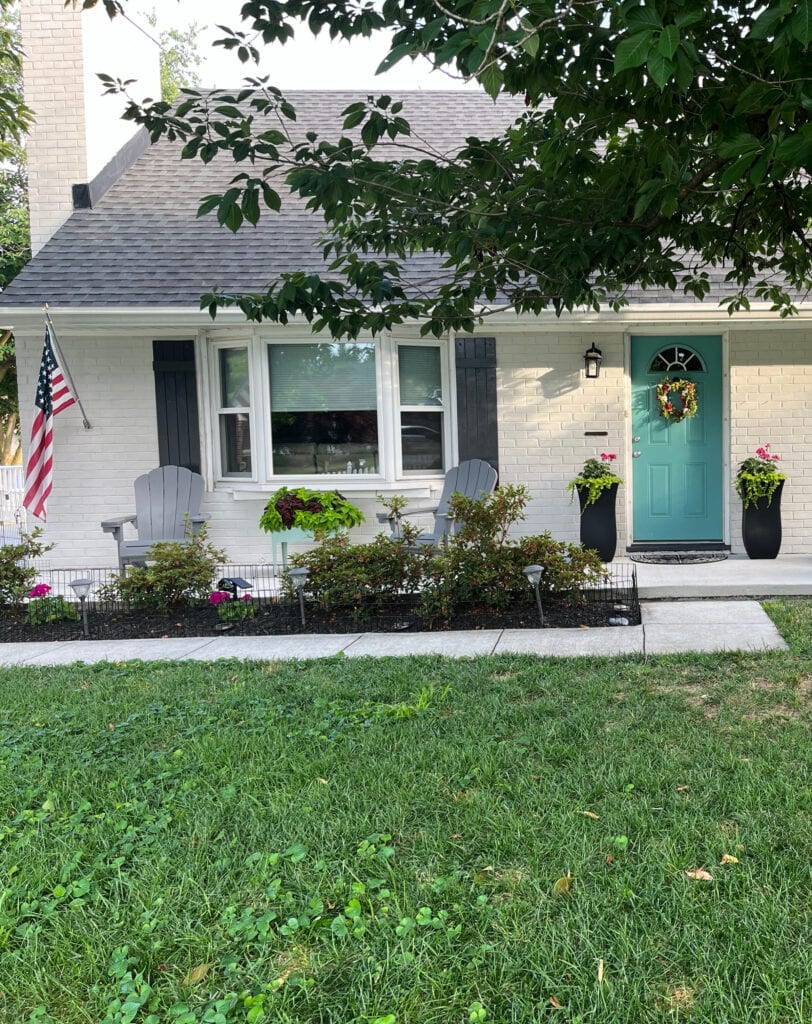 Romabio off-white brick limewash, Wrought Iron shutters, asphalt roof, teal front door and flower box planter box
