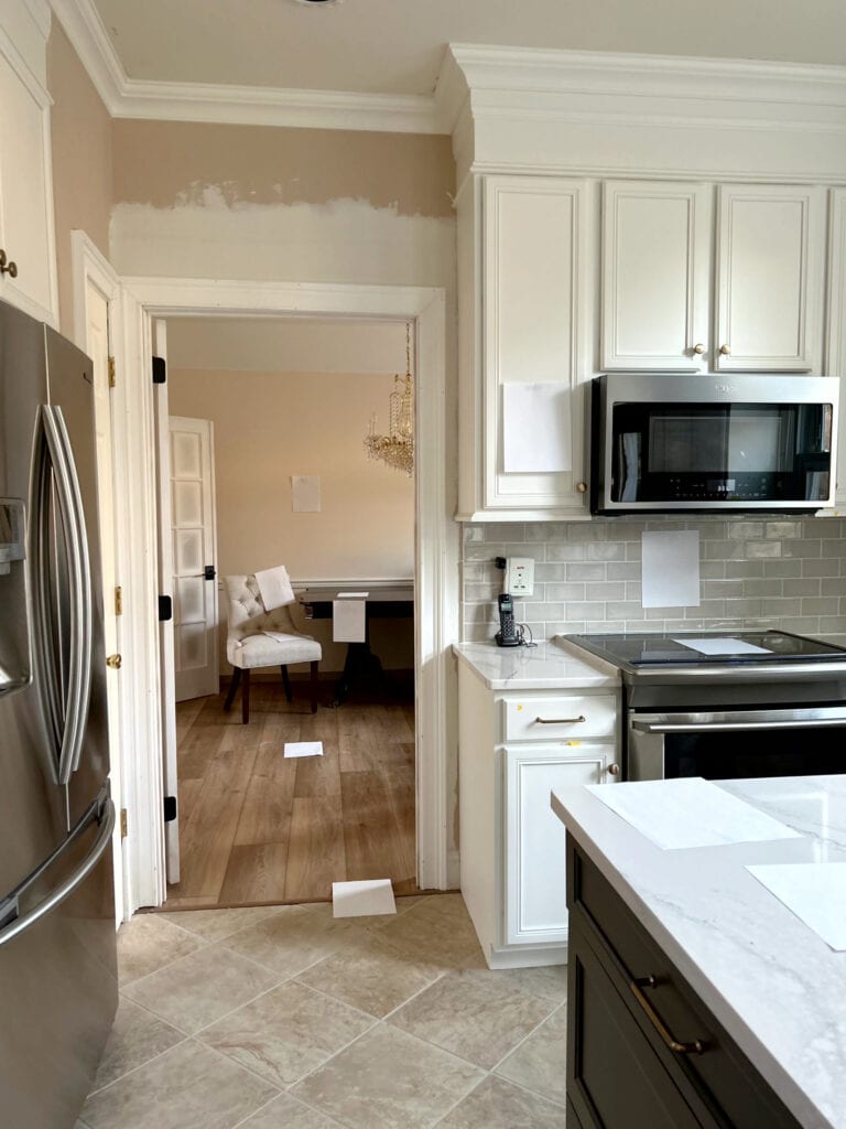 Sherwin Williams Pure White painted wood cabinets, Cambria Lakedale white quartz countertop, beige tile floor, taupe subway tile backsplash