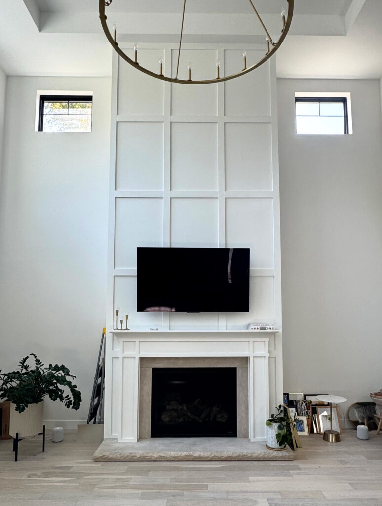 Sherwin Williams Snowbound in great room, vaulted ceiling, grid accent wall fireplace, pink-toned white wash wood floor, Extra White trim and ceiling (1)