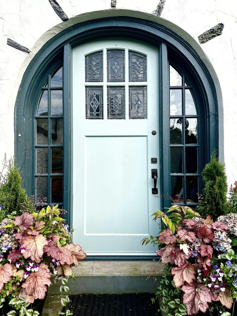 Wythe Blue painted front door, Sherwin Still Water trim, Dover White painted stucco, Tudor style exterior, arched front door