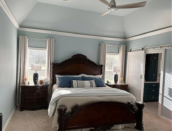 bedroom painted in sherwin williams rain, beige carpet, vaulted ceiling, pure white trim with cherry, dark wood bedroom furniture