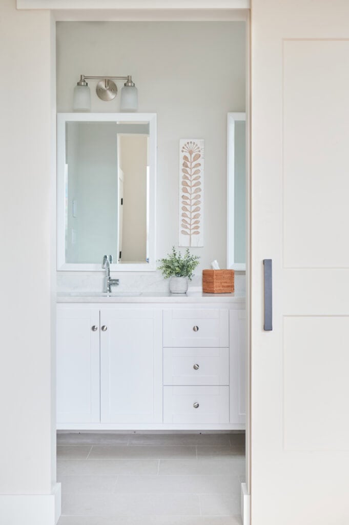 beige tile floor, bathroom, Sherwin Williams Aesthetic White off-white paint color on walls, white vanity, Omnia warm quartz, white mirrors