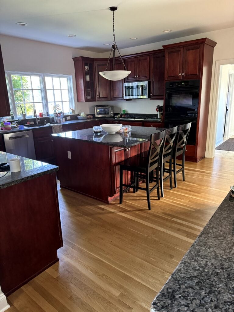 kitchen with red cherry wood cabinets, oak floor, granite countertops before