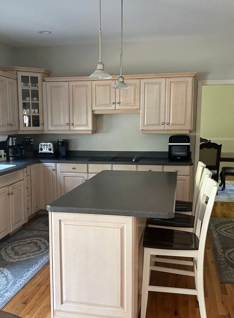 pink pickled oak kitchen cabinets with dark gray laminate countertop, Balboa Mist walls, outdated