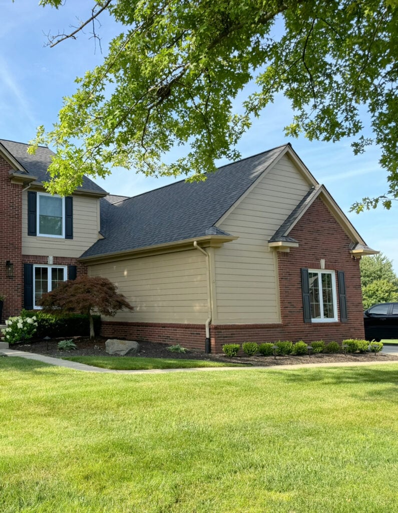 sHERWIN WILLIAMS LATTE BEIGE PAINTED SIDING WITH RED BRICK EXTERIOR, BLACK SHUTTERS