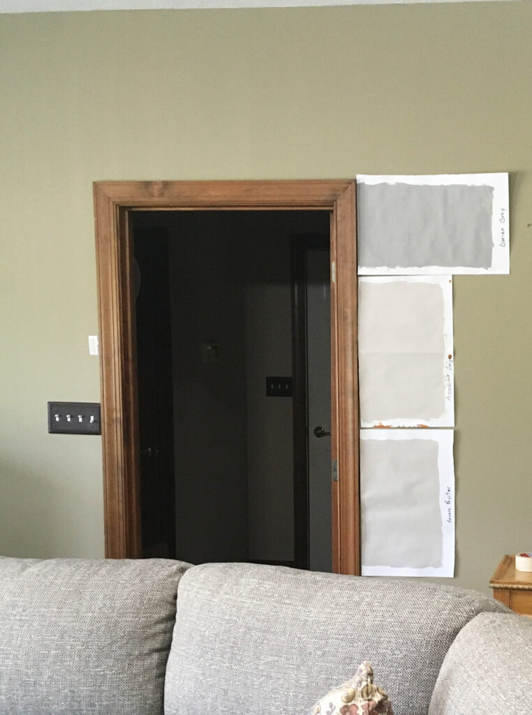 Benjamin Moore Revere Pewter, Sherwin Williams Accessible Beige, Dorian Gray paint color samples against medium to dark wood trim