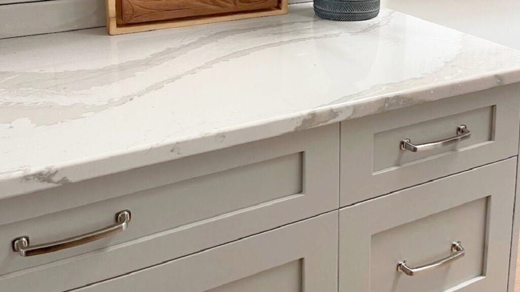 Benjamin Moore Revere Pewter painted kitchen cabinets, nickel knobs, greige subway tile bnacksplash, quartz countertop