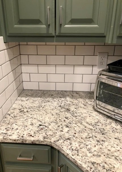 Giallo Ornamental White granite with dark green painted kitchen cabinets, white subway tile backsplash update ideas for wood cabinets