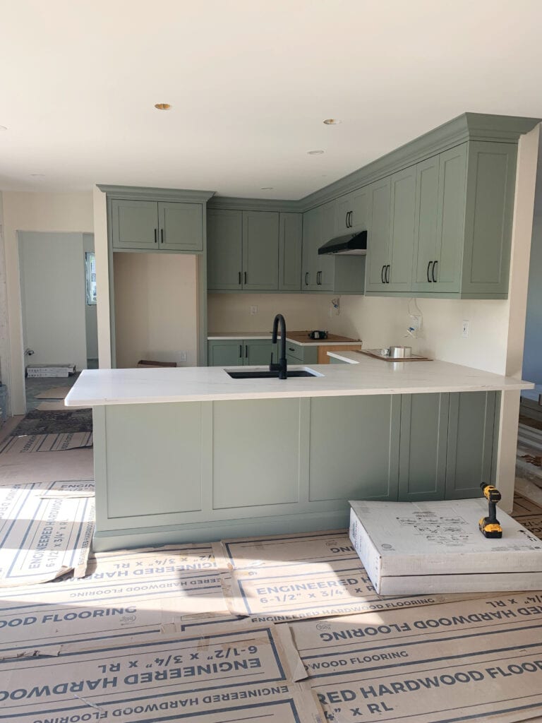 Sherwin Williams Evergreen Fog, green-gray painted kitchen cabinest, white quartz countertop