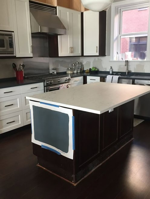Sherwin Williams Grays Harbor, dark blue-green-gray, earthy teal paint color on kitchen cabinets or island. Dark wood floor, off-white quartz countertop