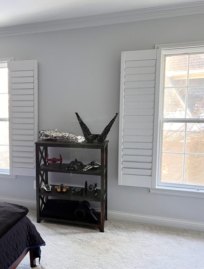 Sherwin Williams Misty gray-blue paint color wiht white shutters, beige carpet in boys bedroom with Starwars or Space theme