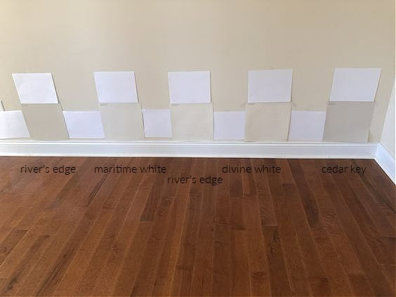 Sherwin Williams River's Edge, Benjamin moore MARITIME WHITE, MODERATE WHITE, DIVINE WHITE, CEDAR KEY paint samples against red-orange wood floor stain