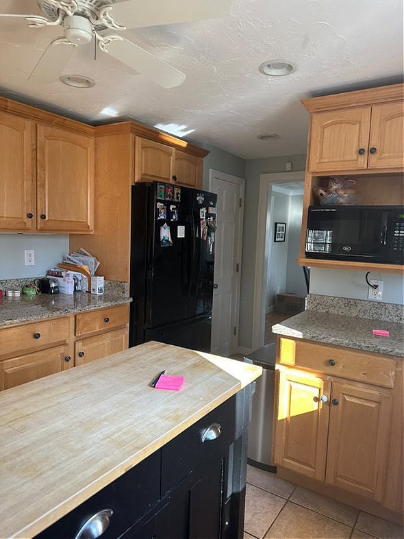 before update ideas, light stained maple wood cabinets, beige tile floor, black island, narrow, black kitchen appliances, granite countertop