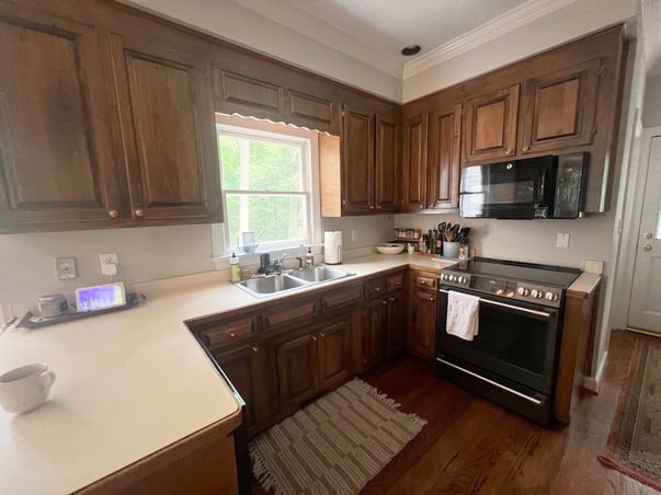 before update, kitchen with dark wood stained cabinets, maybe pine, oak floor, stainless steel appliance, off-white laminate formica countertop with wood edge