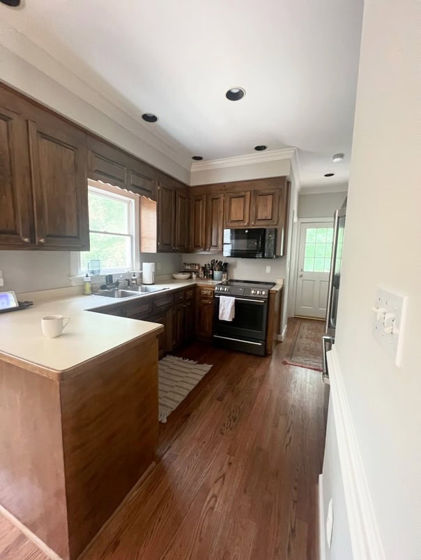 before update, kitchen with off-white laminate formica countertop, oak wood floor, possibly dark pine stained kitchen cabinets