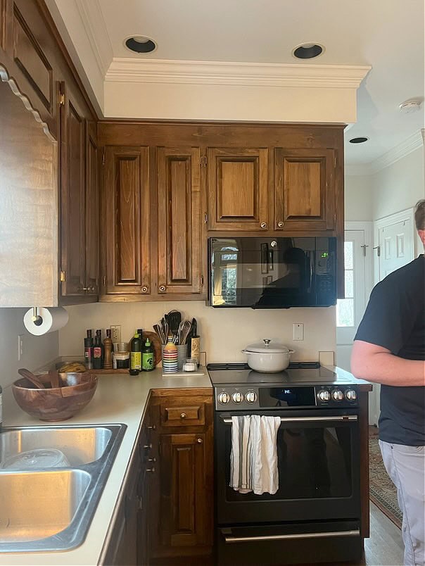 dark wood stained kitchen cabinets, 1980s, possibly pine, oak floor, off-white laminate countertop