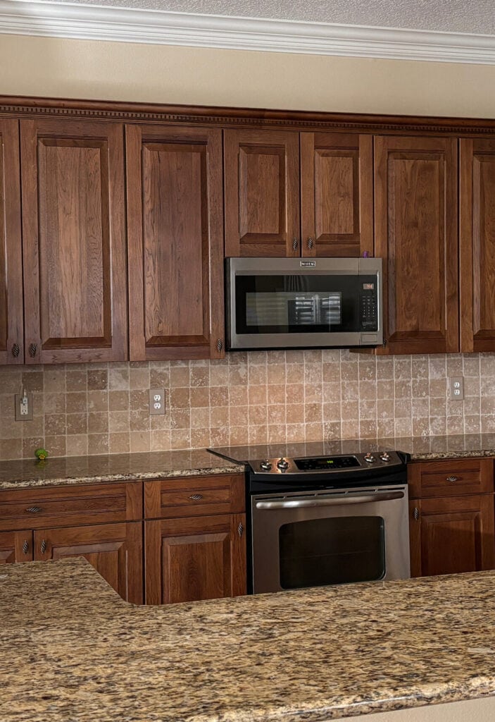 oak wood kitchen cabinets, dark stain, giallo ornamental or Santa Cecilia granite countertop, travertine tile backsplash update ideas