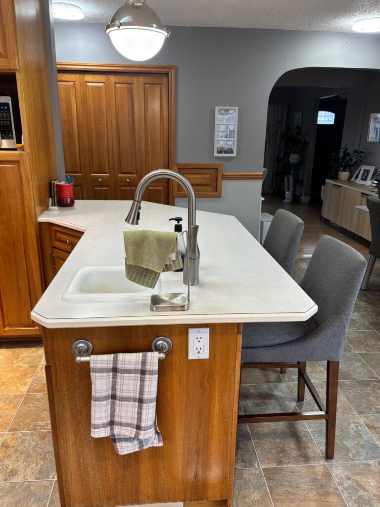 BEFORE PHOTO Kitchen with aged, darkened cherry wood cabinets, linoleum tile look floor, wood trim, laminate countertop