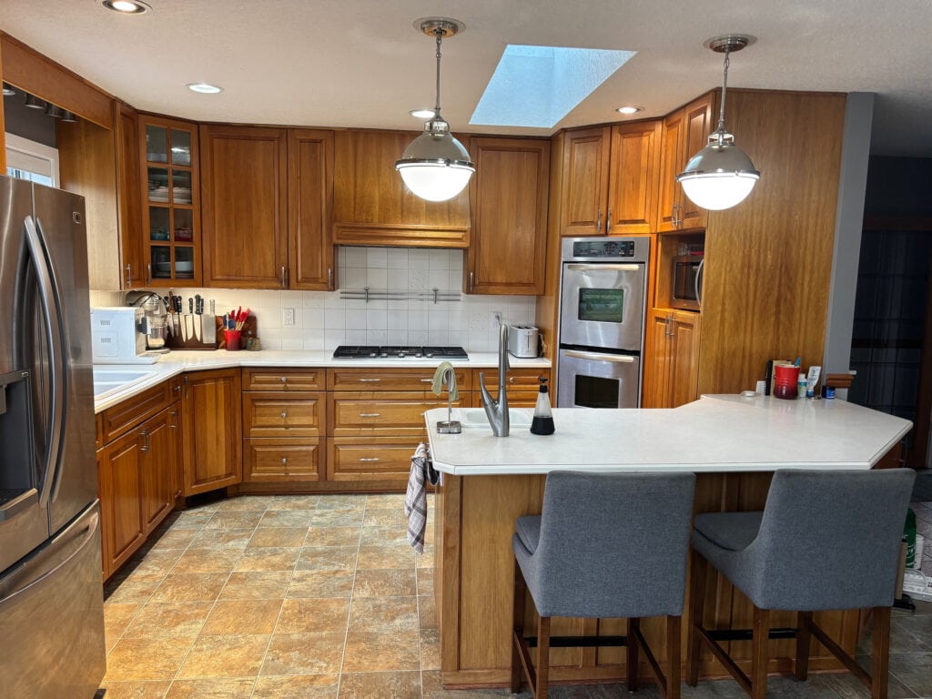BEFORE UPDATE IDEAS kitchen with peninsula, linoleum floor, darkened natural cherry wood cabinets, off-white laminate countertop